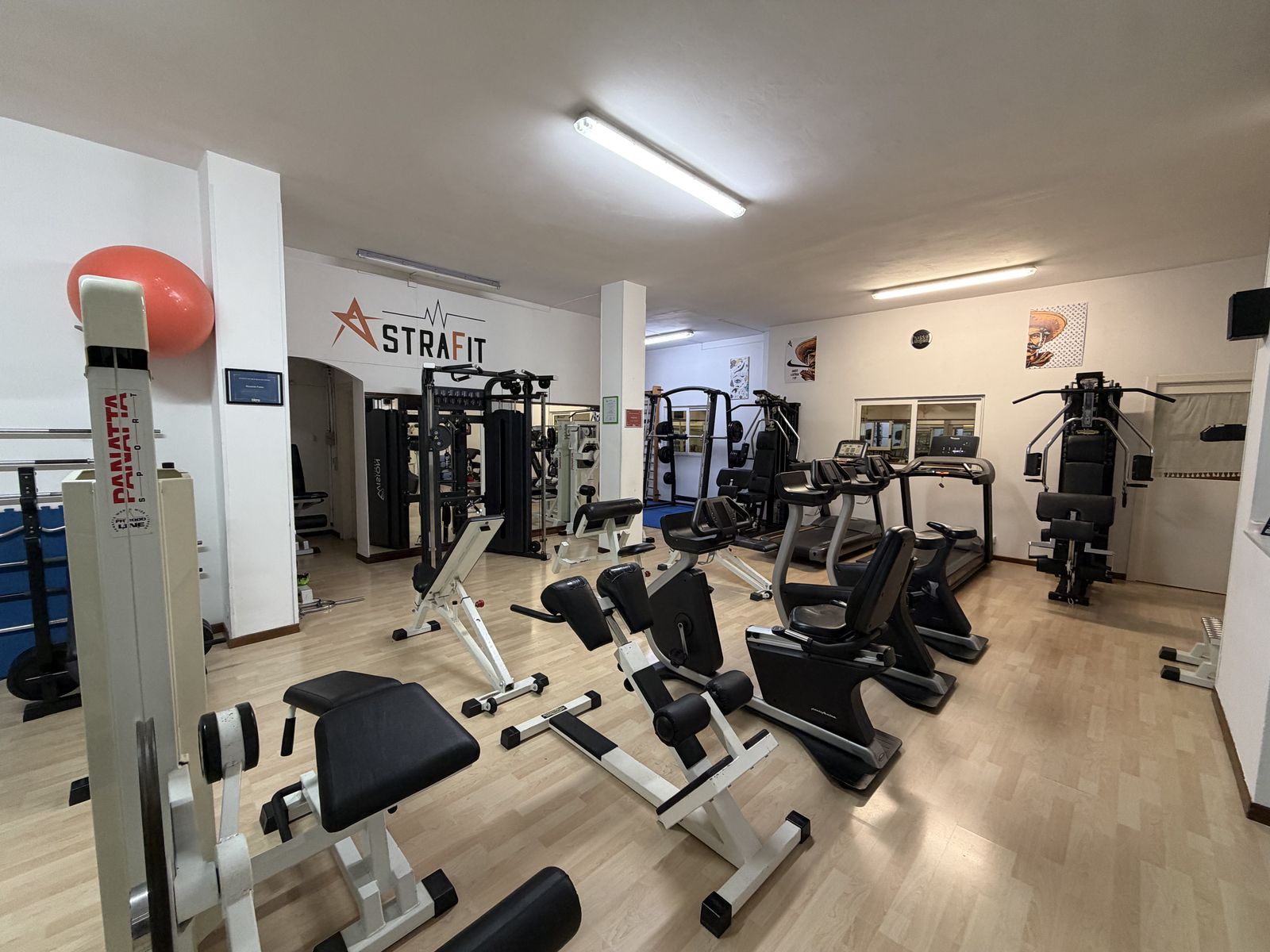 Sala attrezzi AstraFit con macchine isotoniche, cyclette e tapis roulant