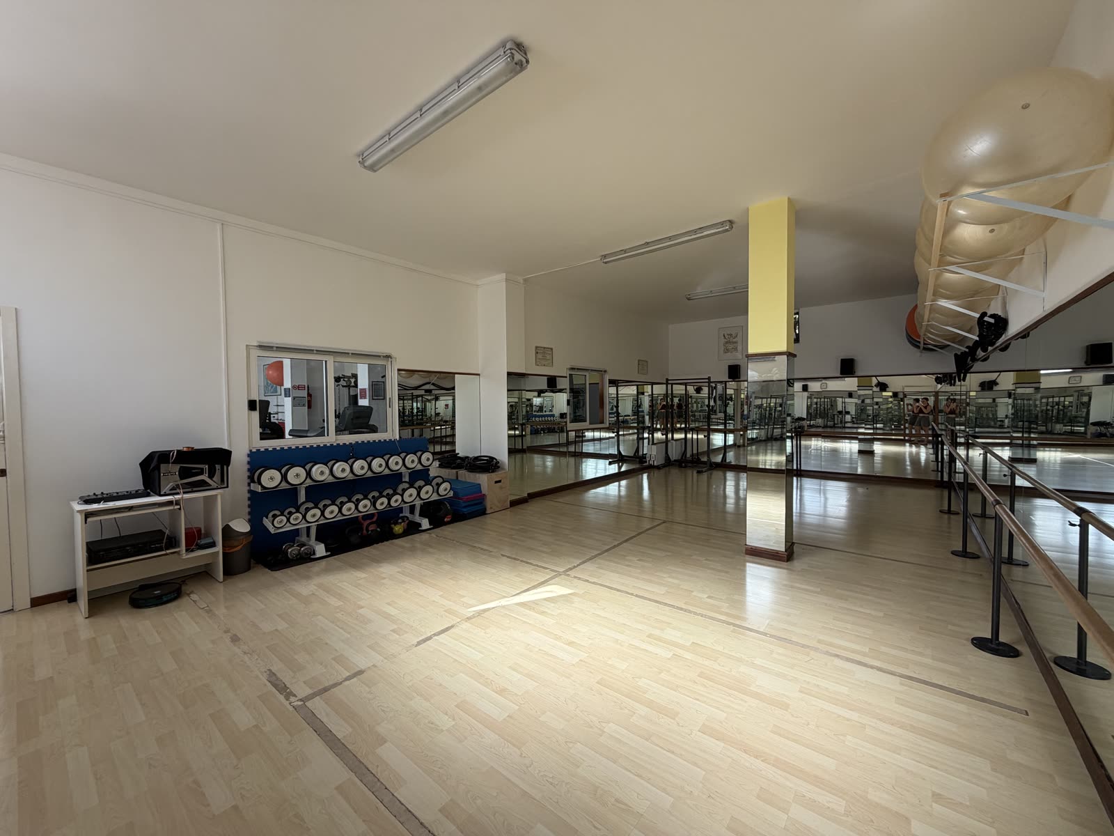 Sala corsi AstraFit: rastrelliera con manubri, step e tappetini