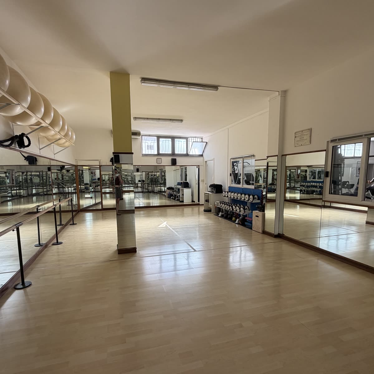 La sala corsi di AstraFit: parquet, specchi a parete e sbarra
